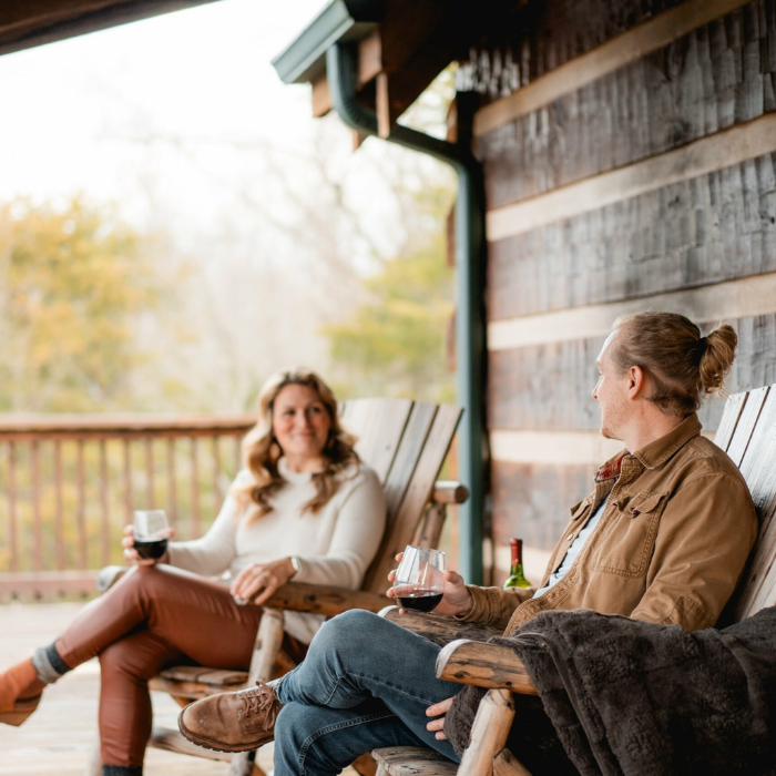 JC_Home_Visit Photo of a young male and female couple enjoying a drink on a cabin porch in jefferson county tn